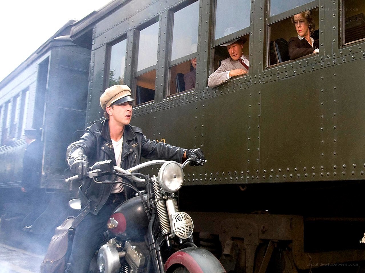 Man on motorcycle near train