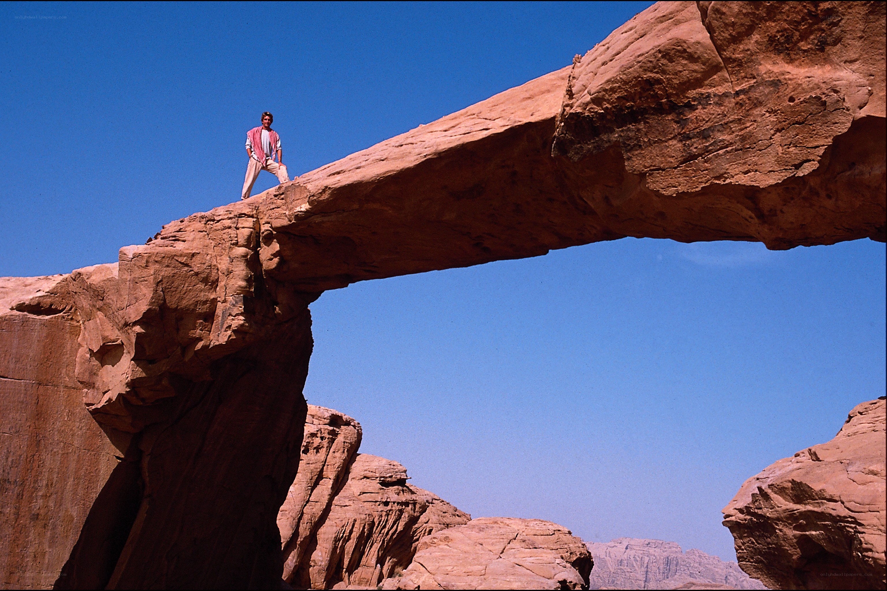 Man on natural rock arch