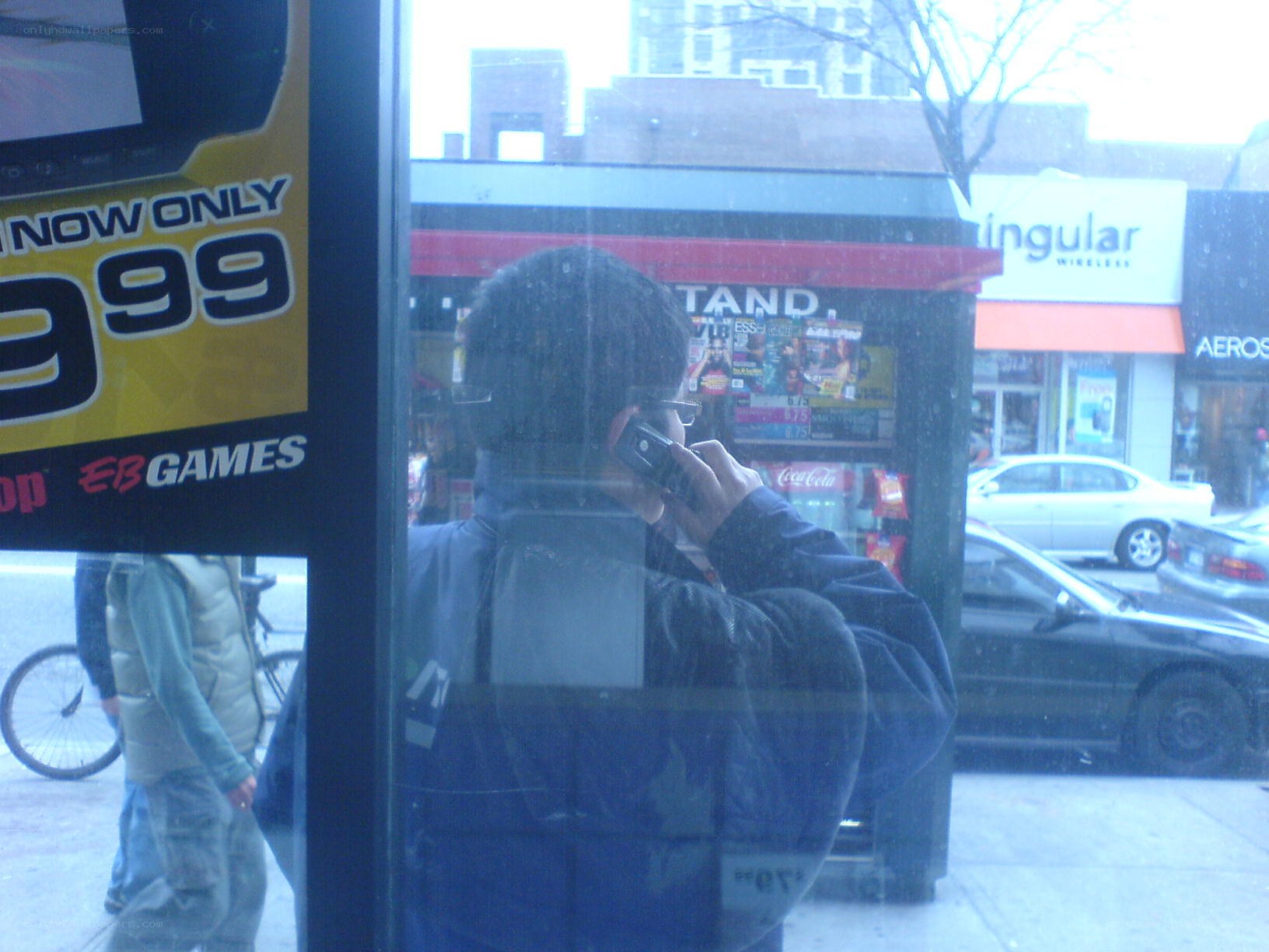 Man on phone at newsstand