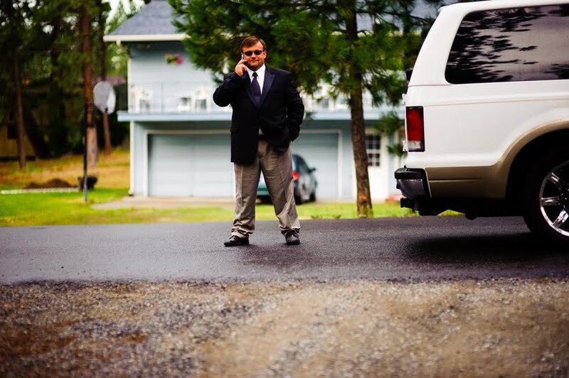 Man on phone near white SUV