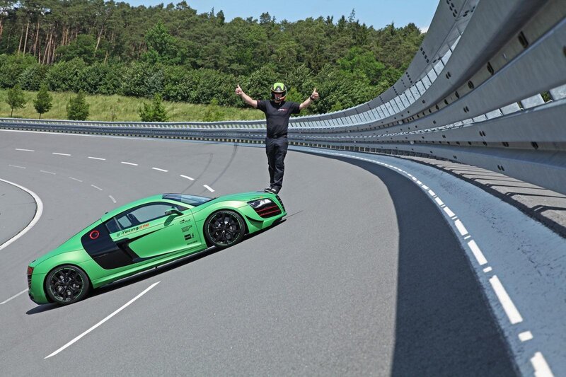 Man on race track with green car