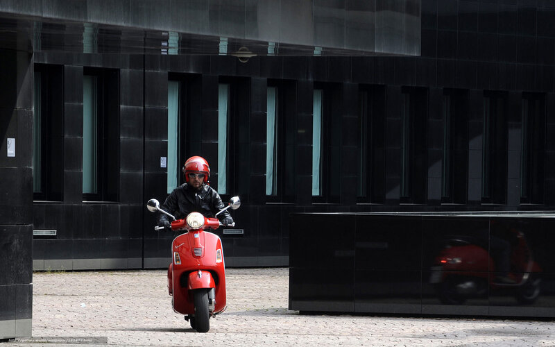 Man on red scooter in city