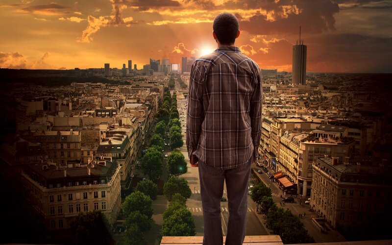 Man on Rooftop Overlooking City — Orange
