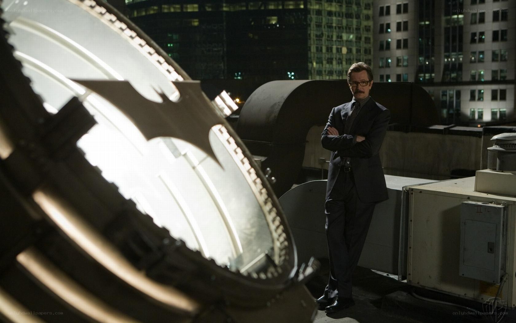 Man on rooftop with bat symbol