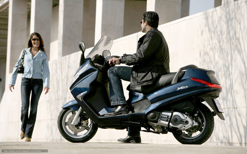 Man on scooter with woman walking