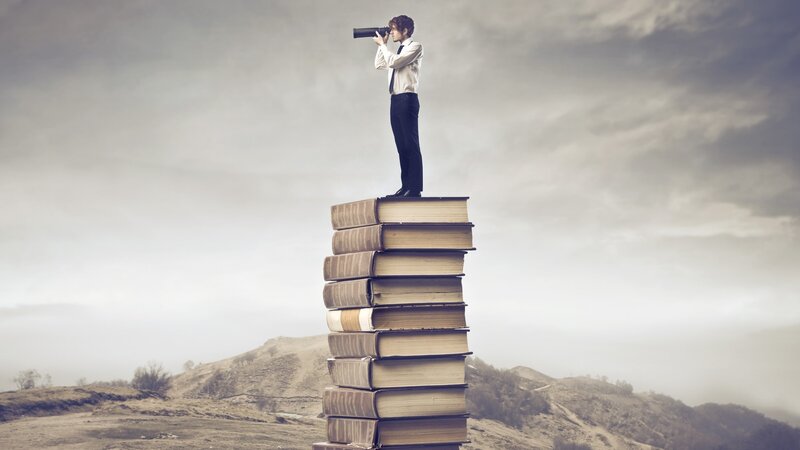 Man on Stack of Books — Gray, Dramatic