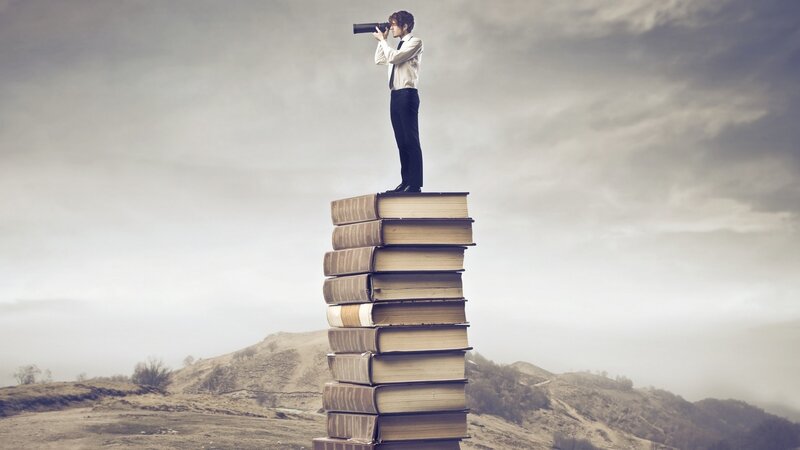 Man on Stack of Books — Gray