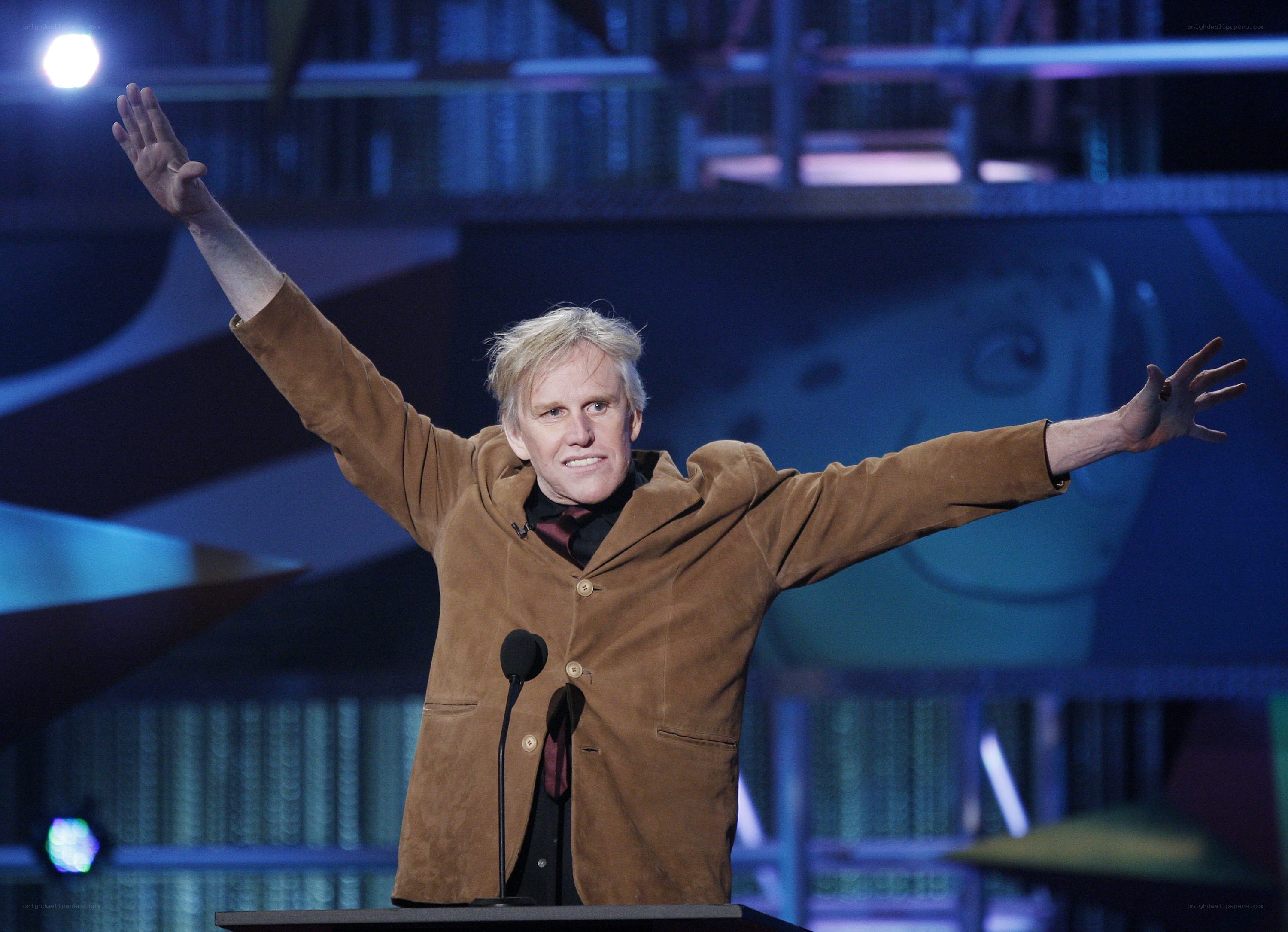 Man on stage with arms raised