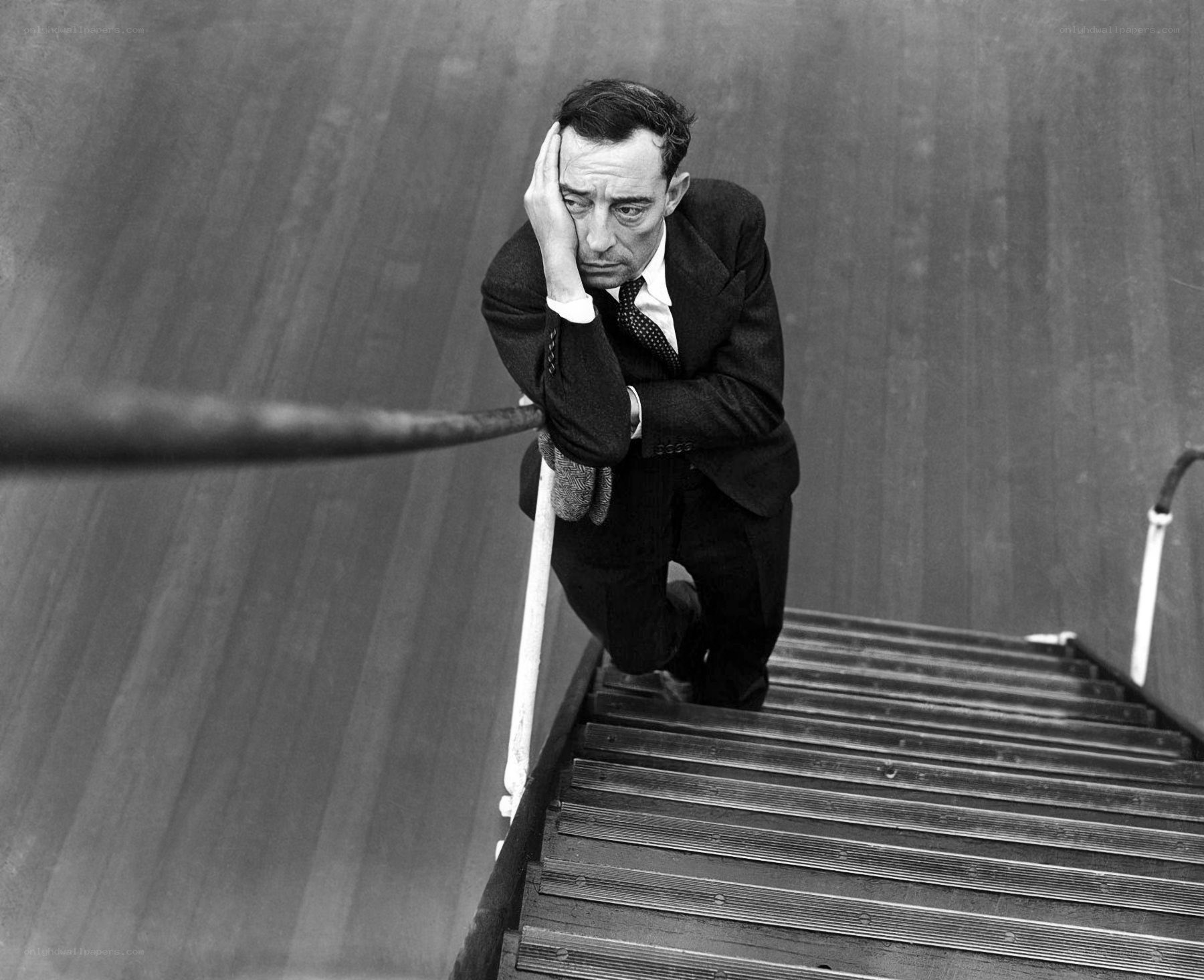Man on staircase with hand on face