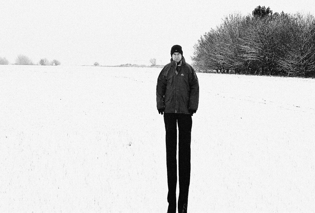 Man on stilts in snowy field