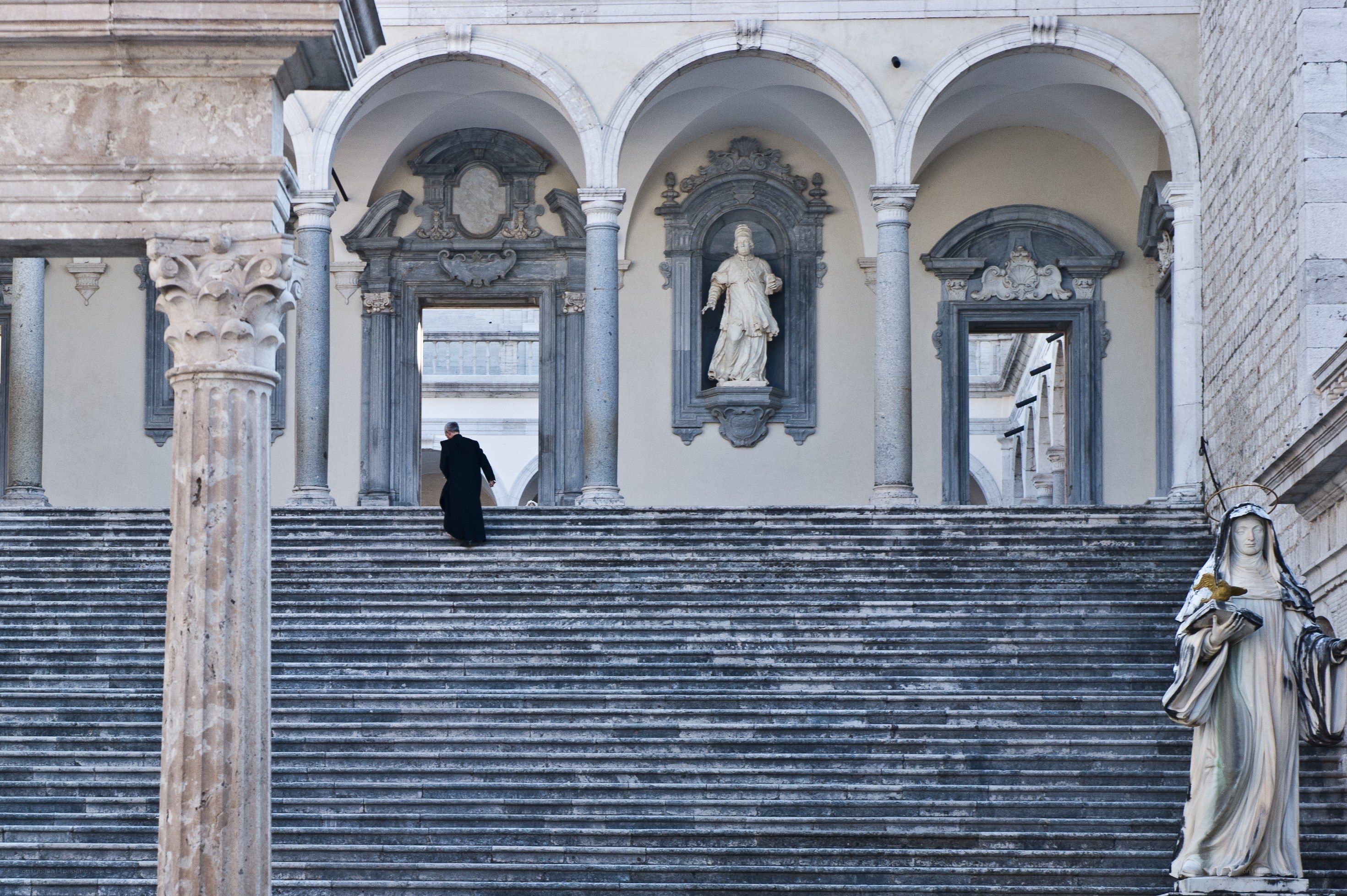 Man on stone steps with statues