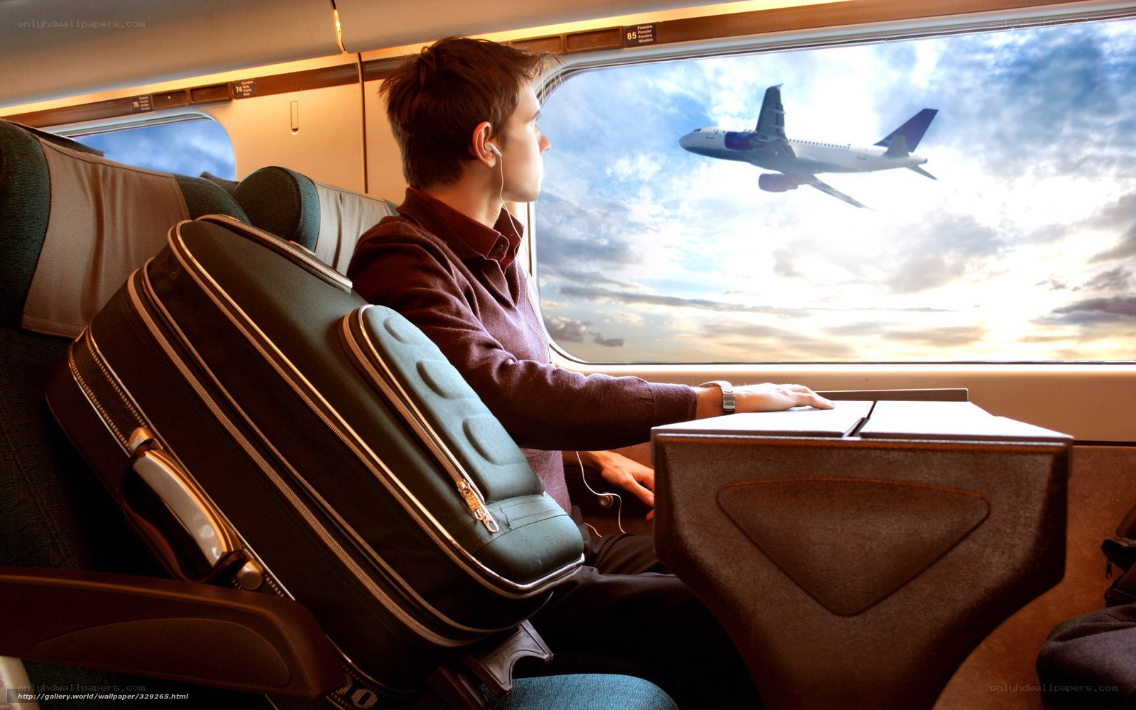 Man on train watching airplane