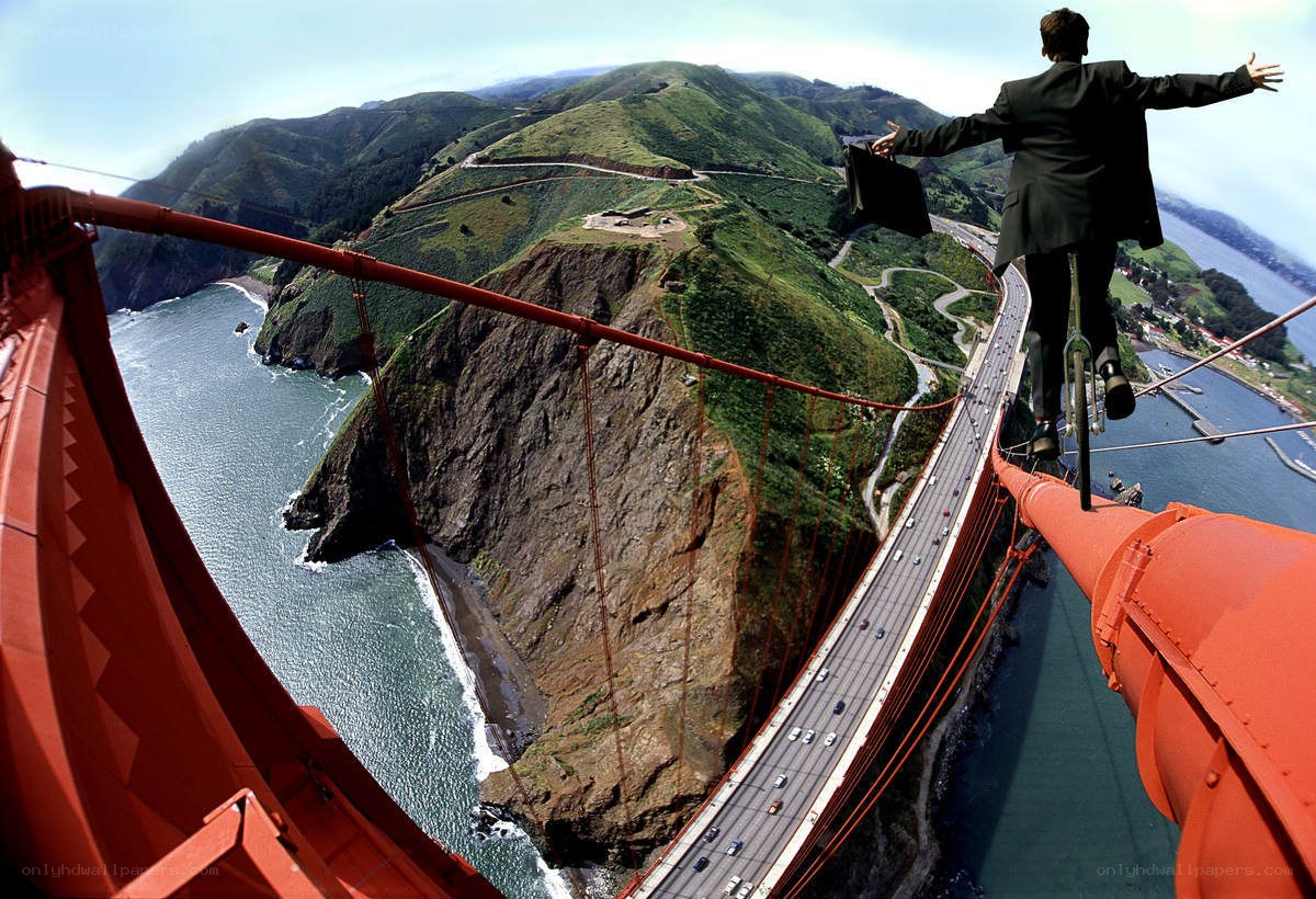 Man on unicycle over bridge