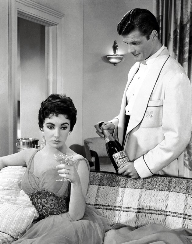 Man opening champagne for woman