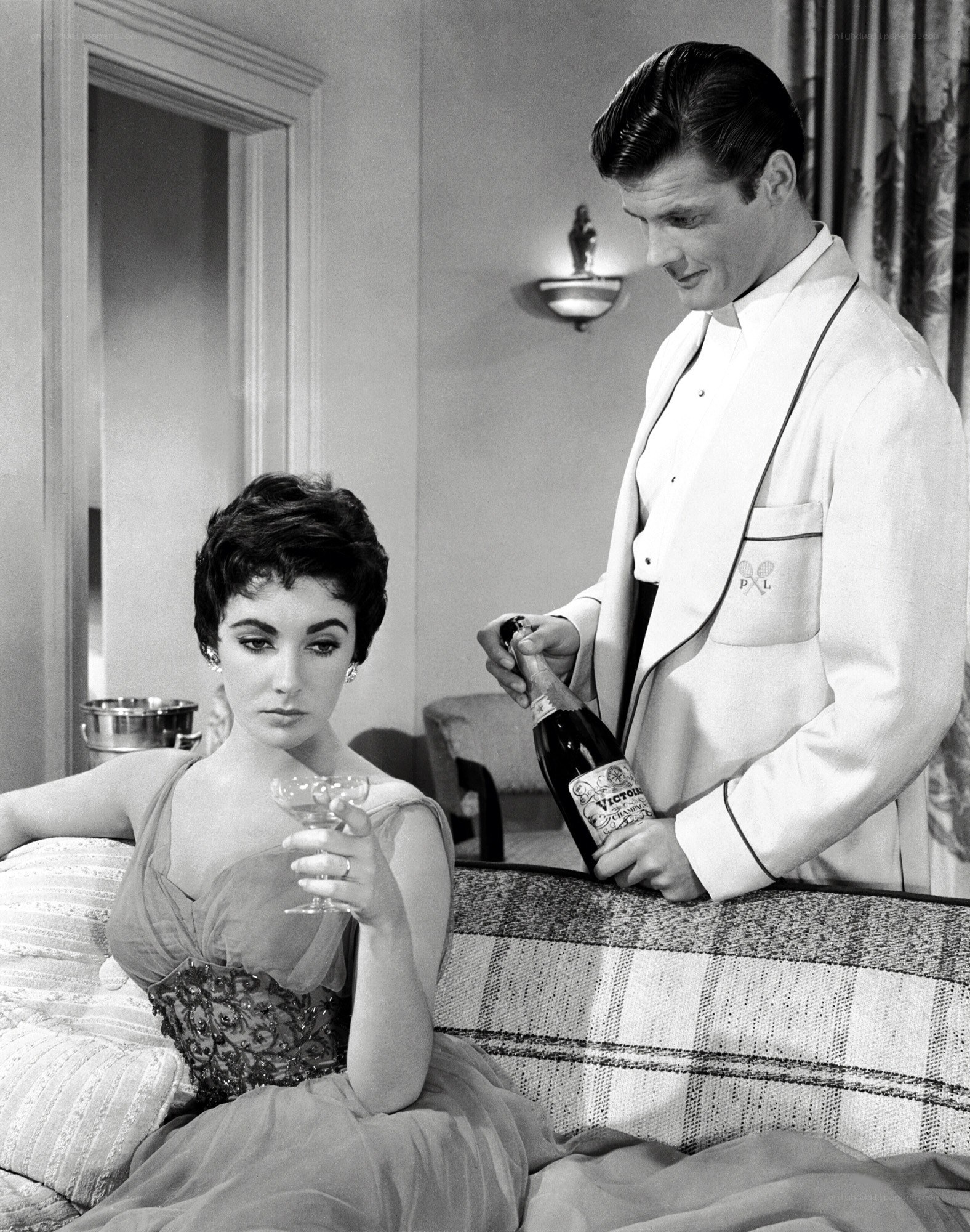 Man opening champagne for woman