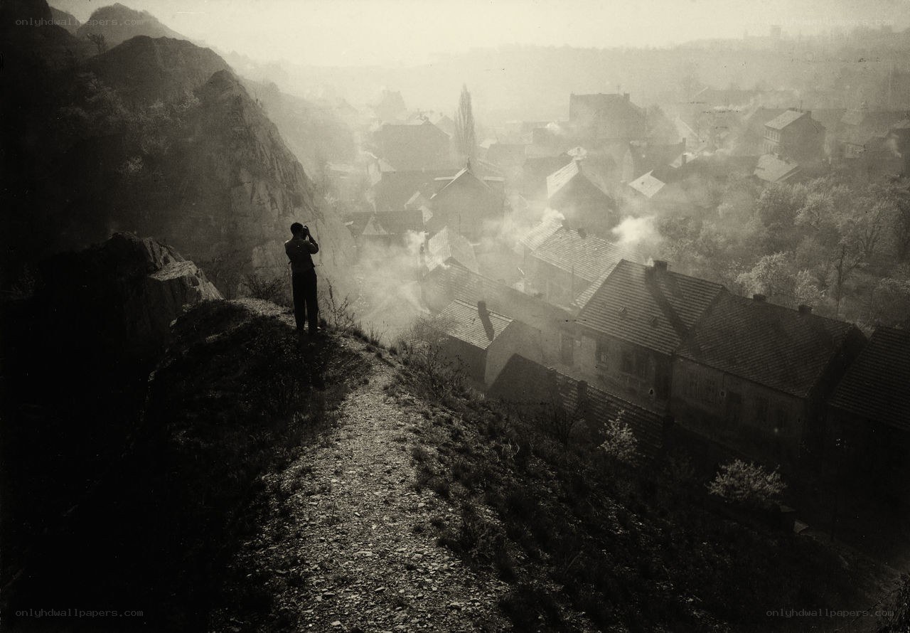 Man overlooking a misty village