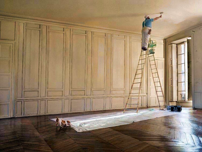 Man painting ceiling on ladder