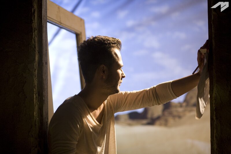man painting in desert