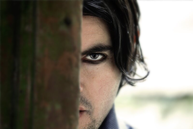 man peeking from behind a post