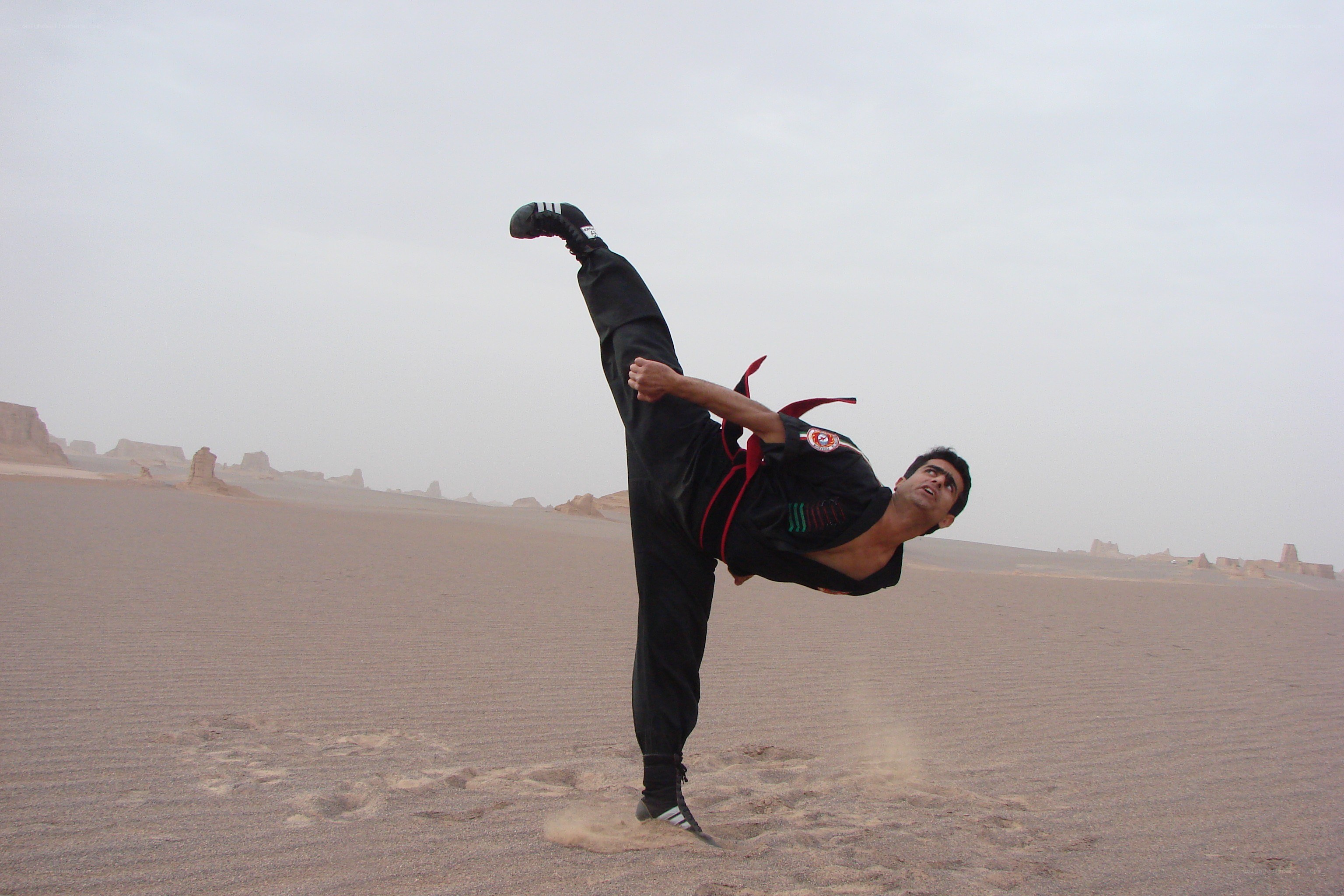 Man performing high kick in desert