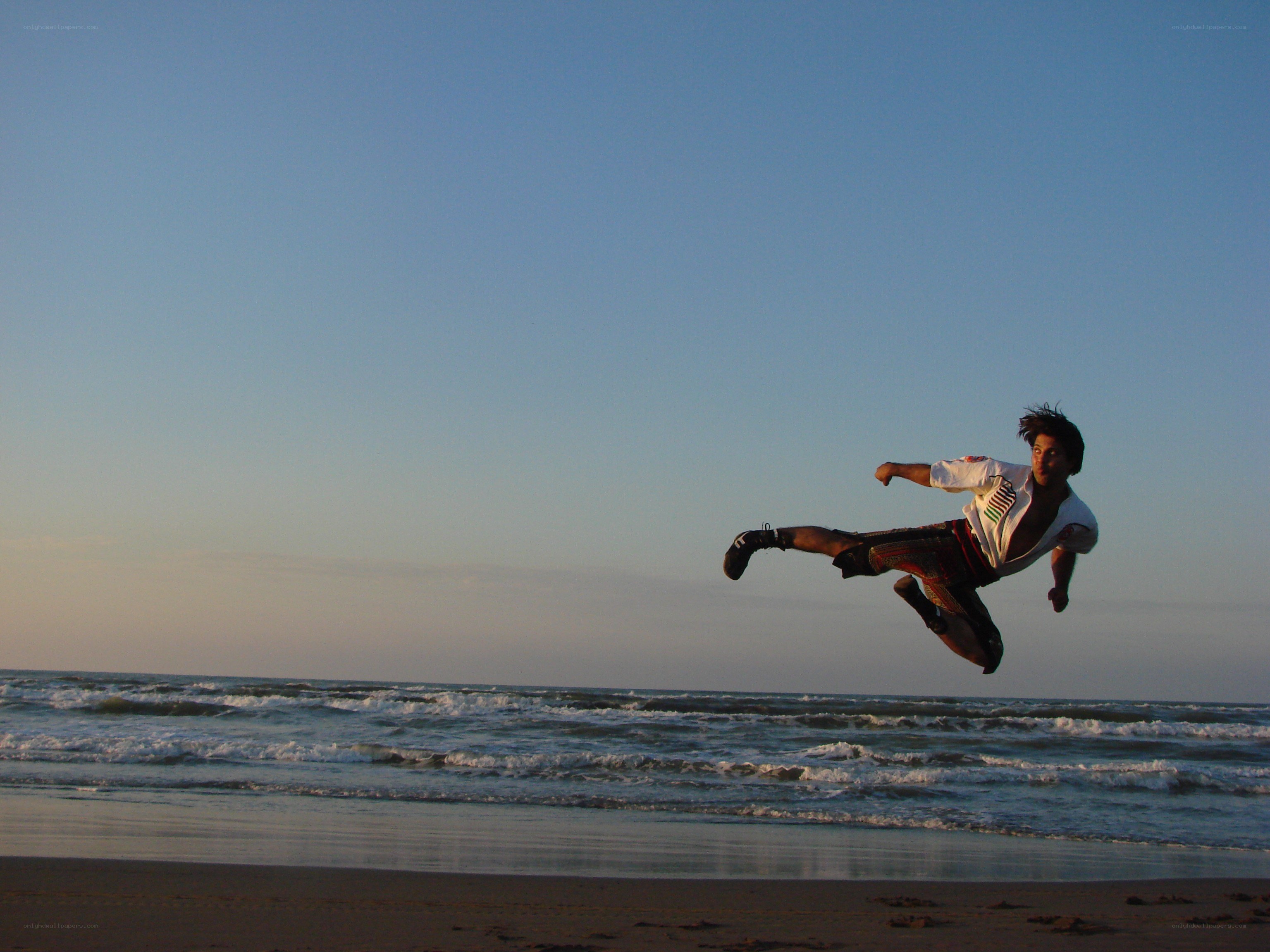 Man performing kick on beach
