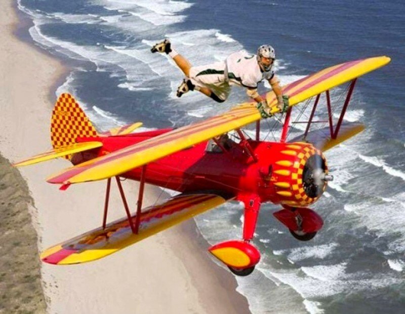 man performing stunt on biplane