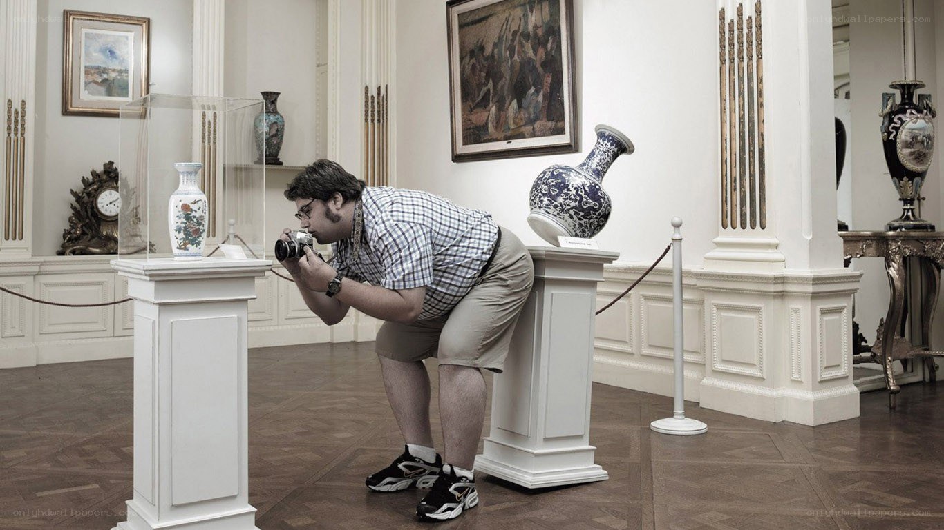 Man photographing museum artifacts