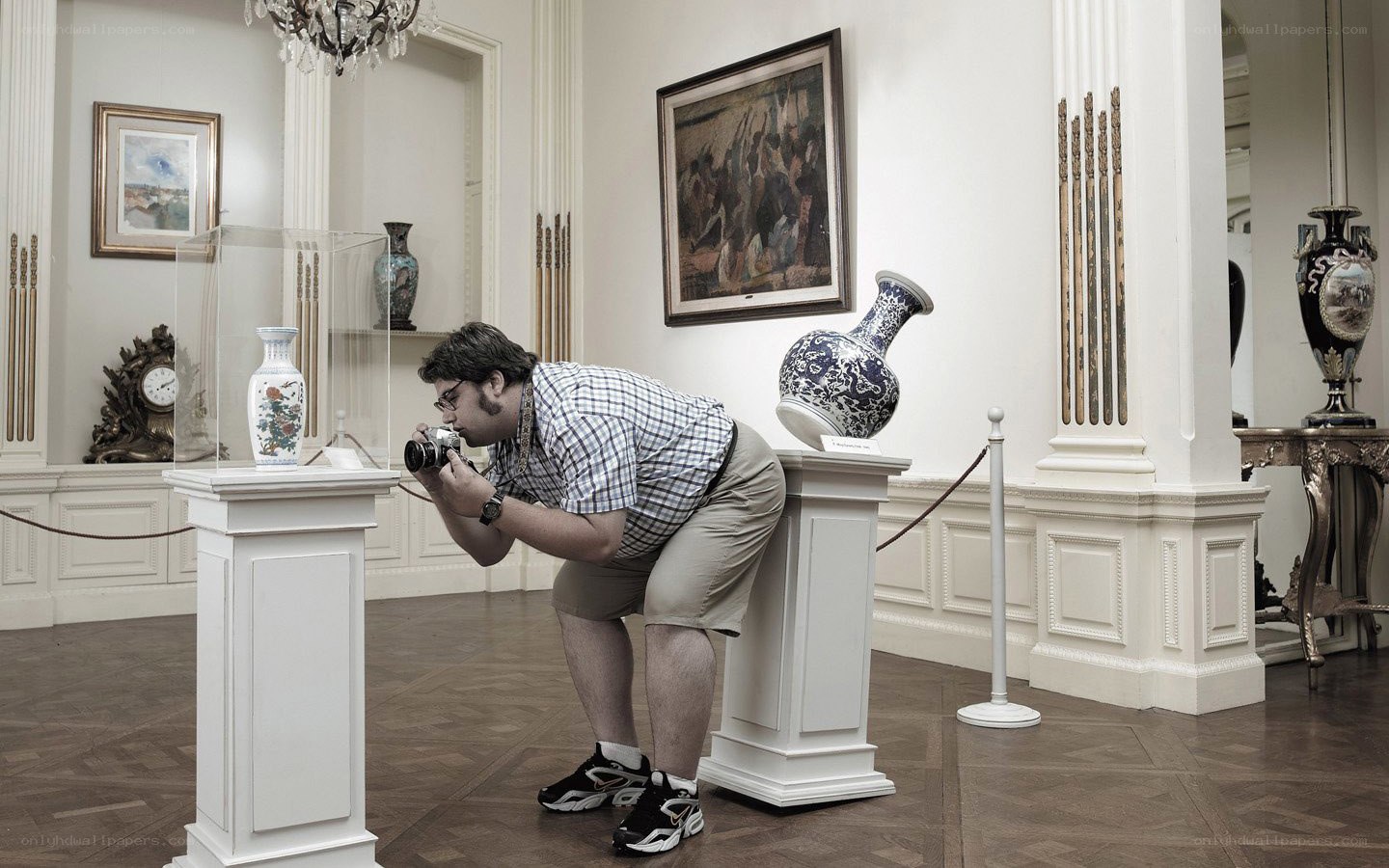 Man photographing vases in a gallery