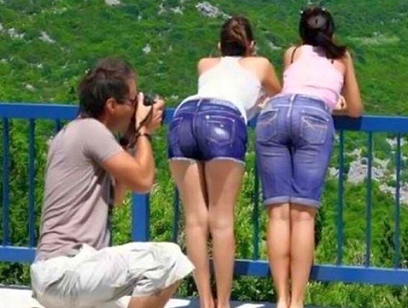 Man photographing women at railing