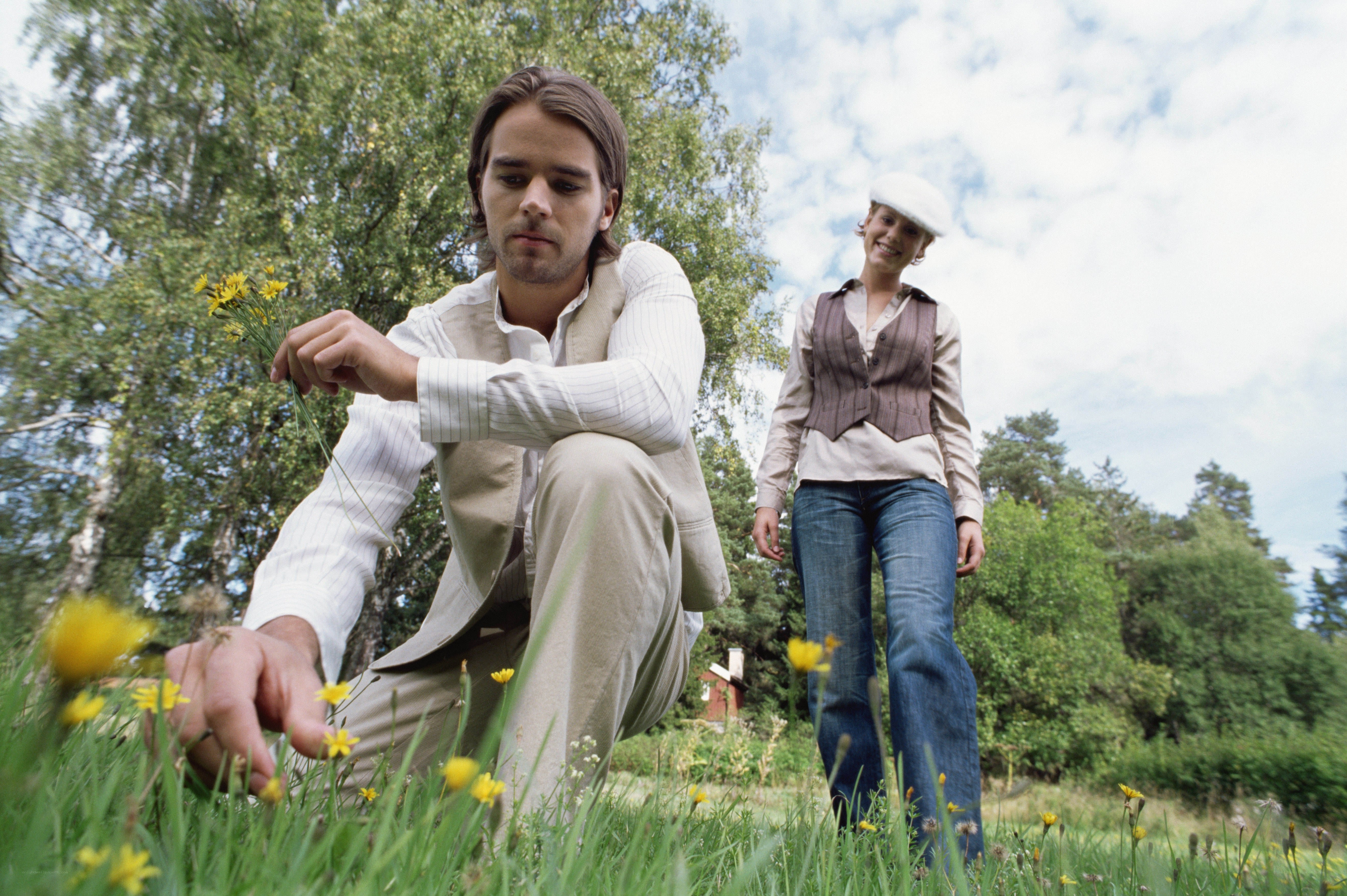 Man picking flowers in a field