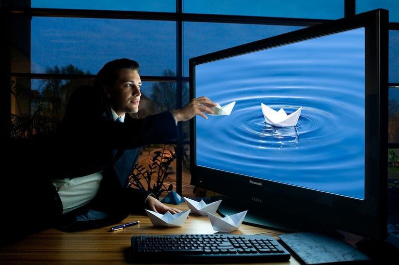 Man Placing Paper Boat