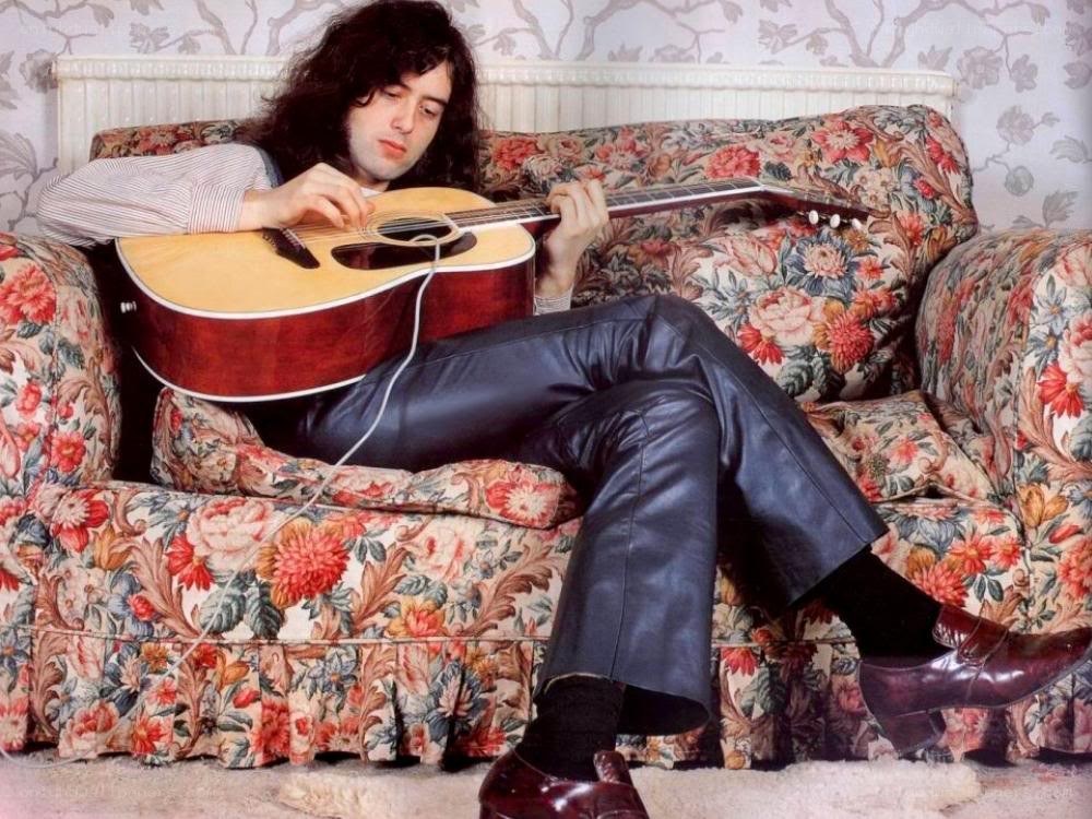 man playing acoustic guitar on couch