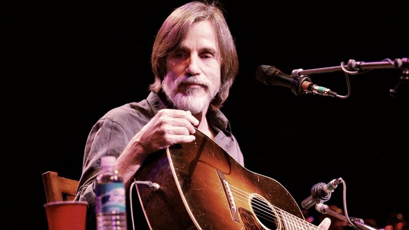 man playing acoustic guitar on stage