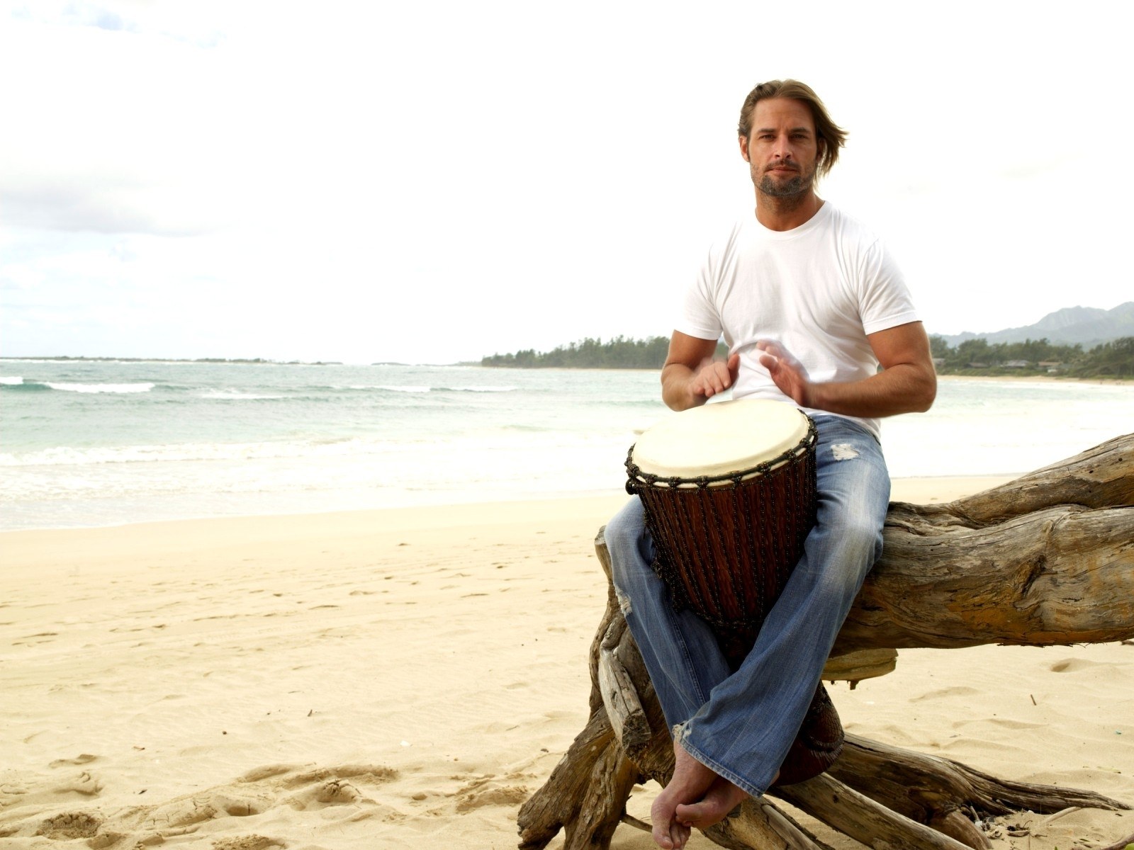Man playing djembe on beach