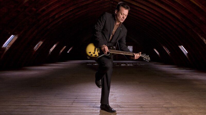 Man playing electric guitar in attic