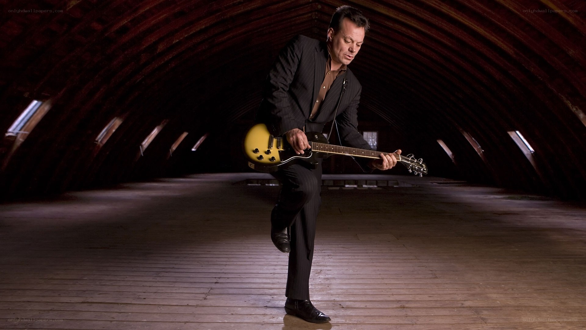 Man playing electric guitar in attic