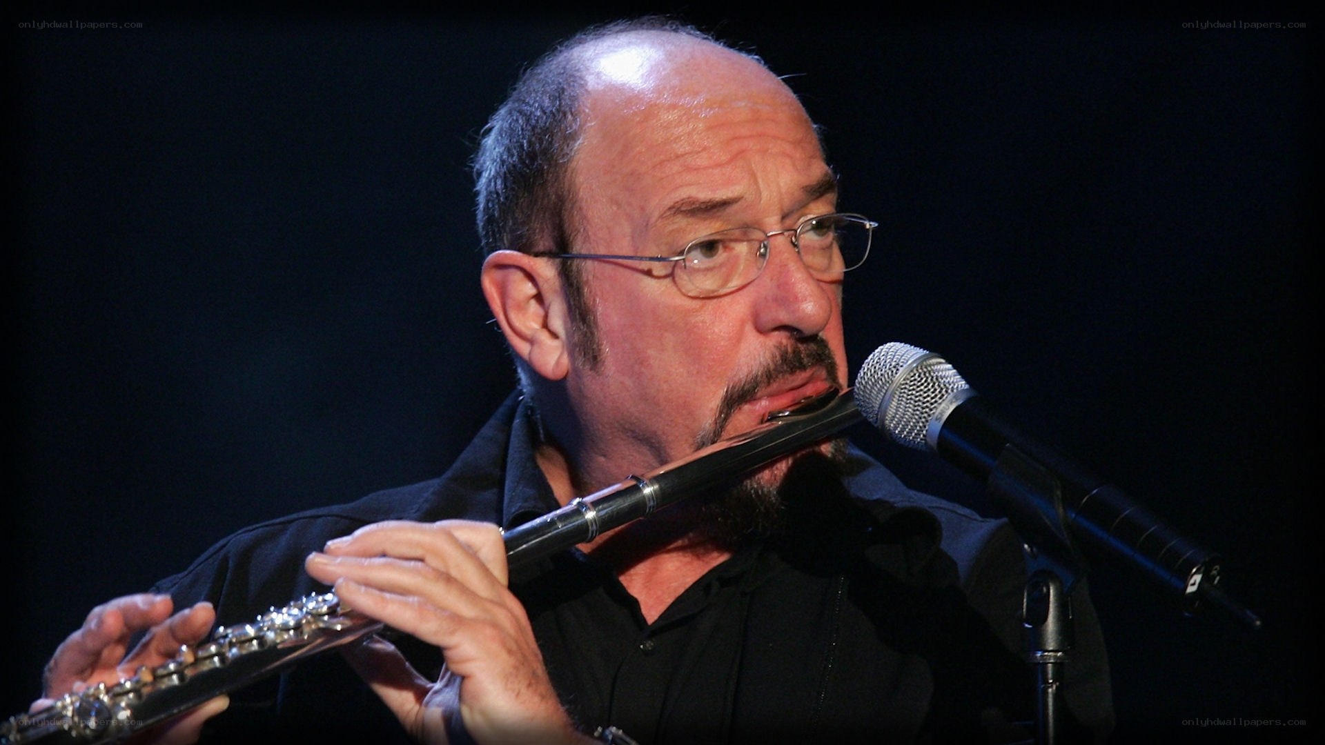 man playing flute on stage