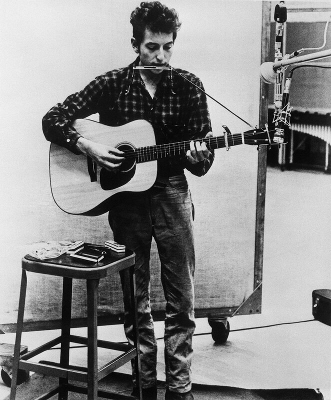 man playing guitar and harmonica