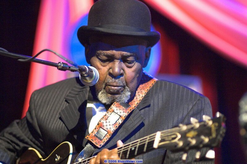 Man Playing Guitar — Black, Focused, Photograph, Microphone