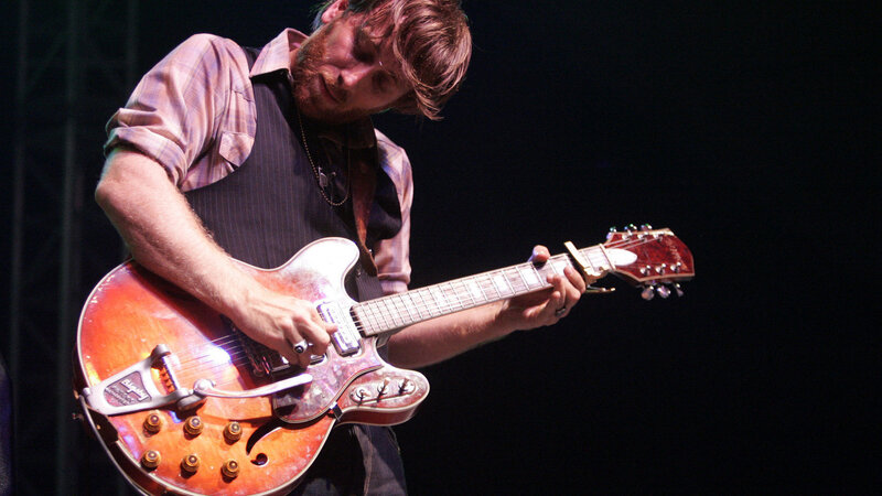 Man Playing Guitar — Brown, Focused
