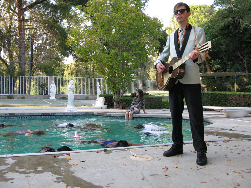Man playing guitar by pool