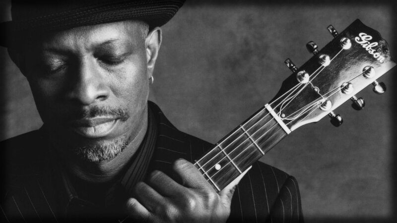 man playing guitar in black and white