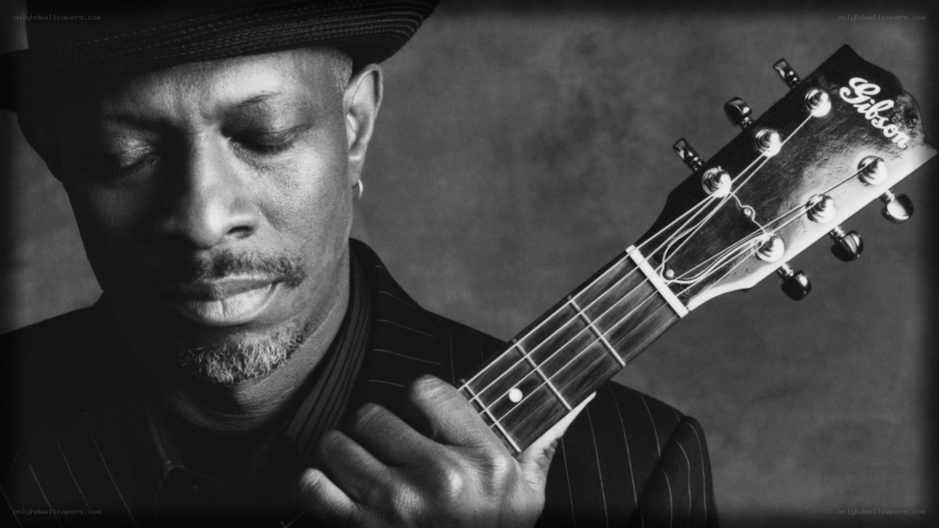 man playing guitar in black and white