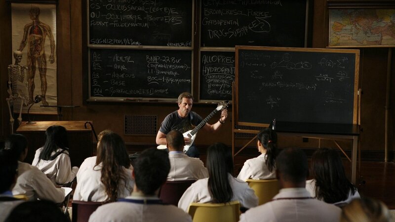 Man Playing Guitar in Classroom