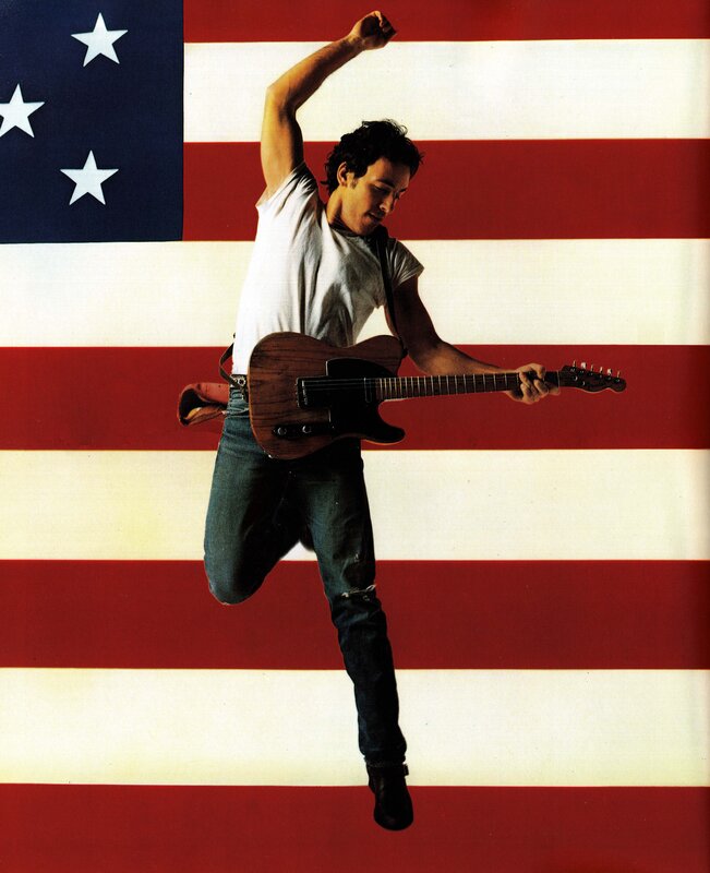Man playing guitar in front of flag