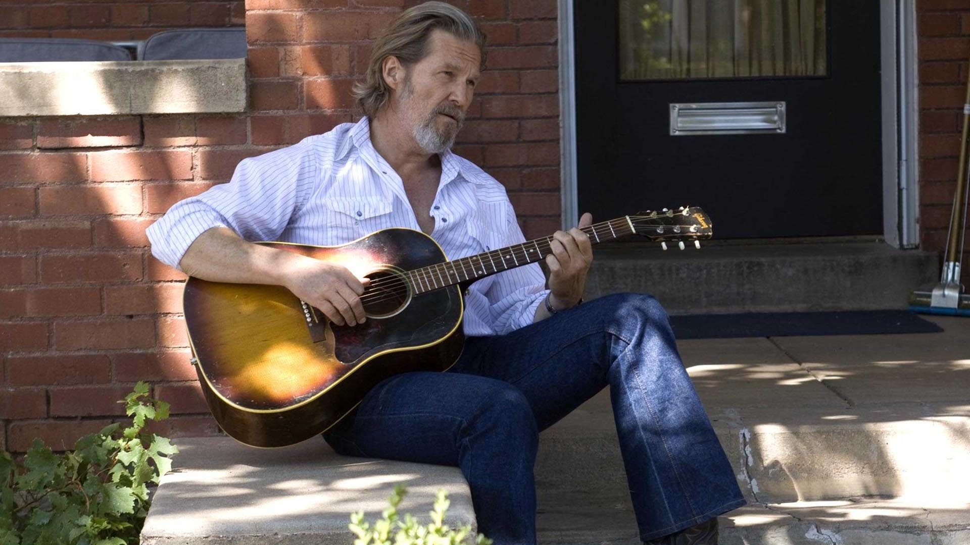 man playing guitar on porch