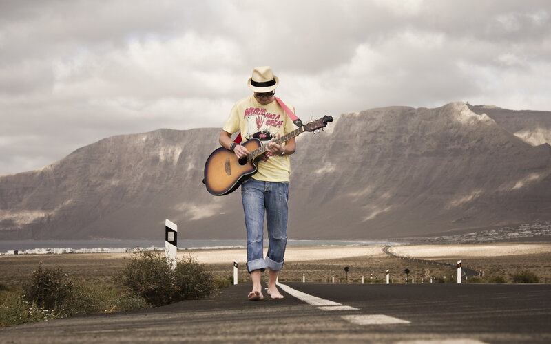 Man Playing Guitar on Road — Brown