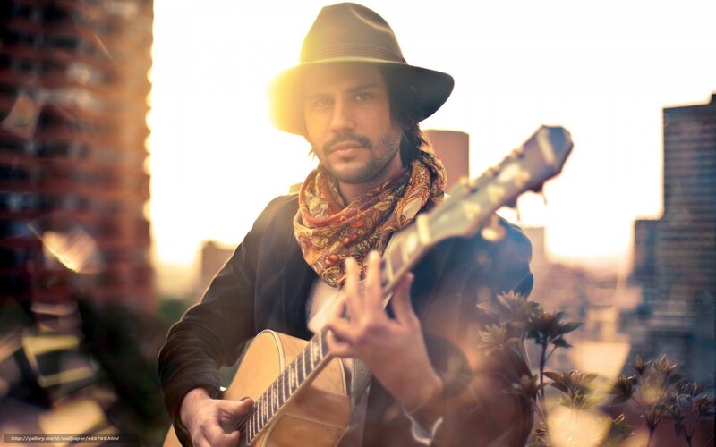 man playing guitar on rooftop