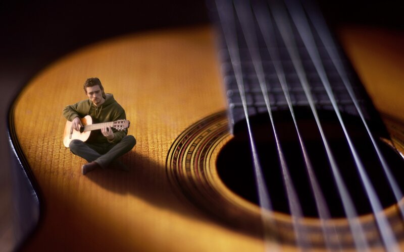 Man playing guitar on soundboard