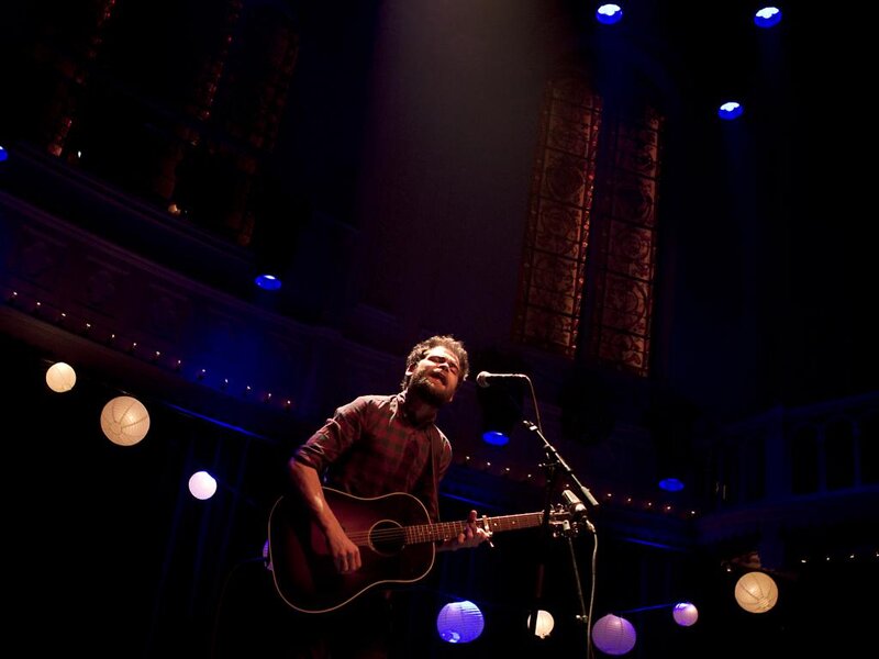 Man Playing Guitar on Stage — Black, Dramatic, Night, Photograph, Microphone